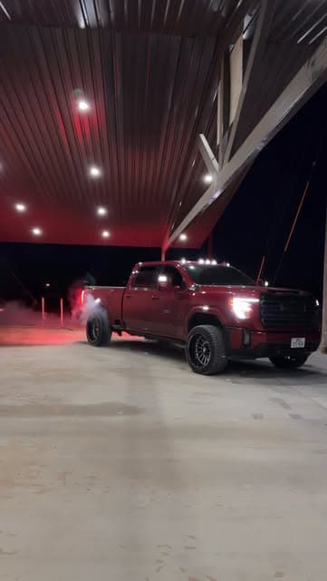 Red performance truck under shop lights at night