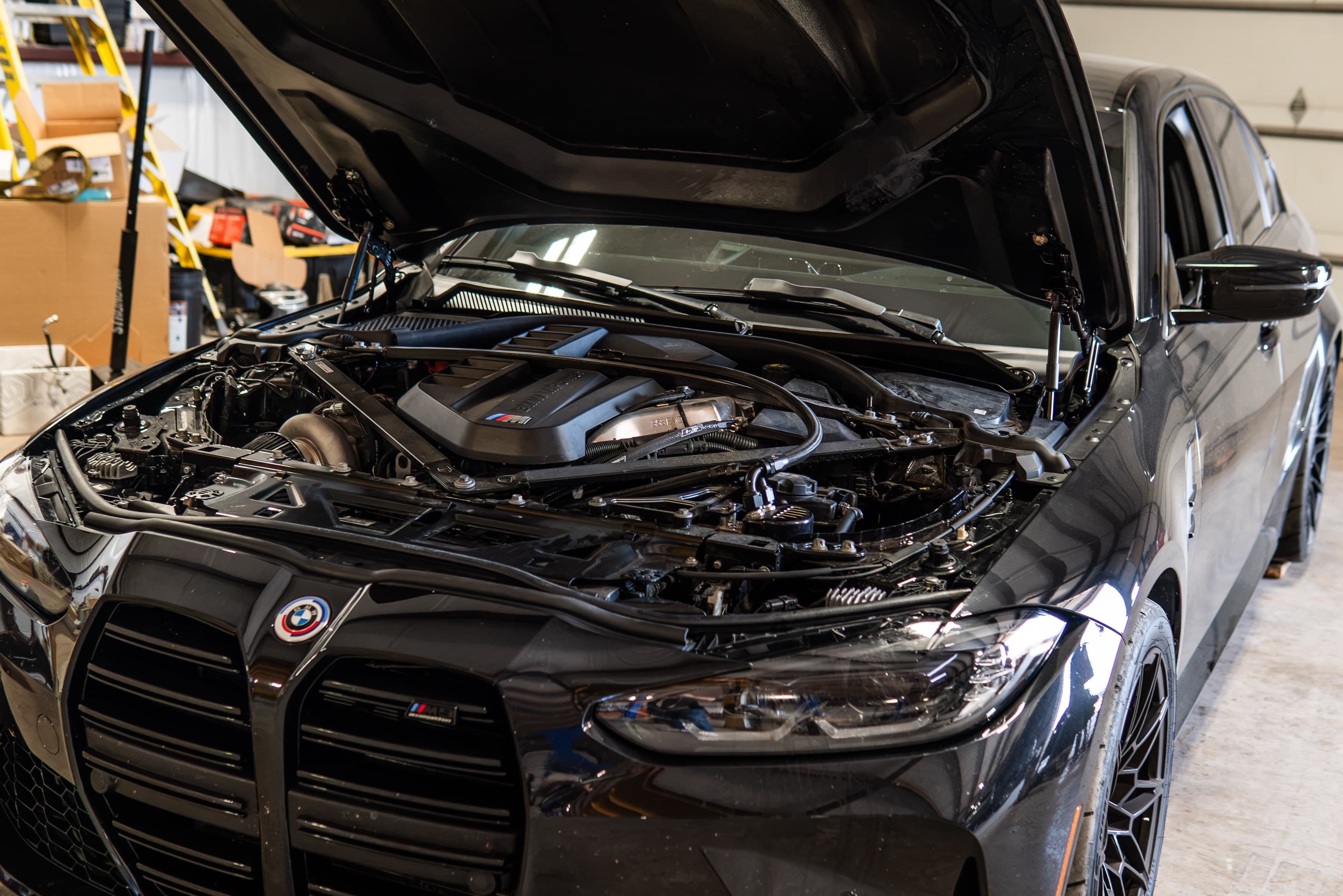 Performance BMW with its hood open in the shop