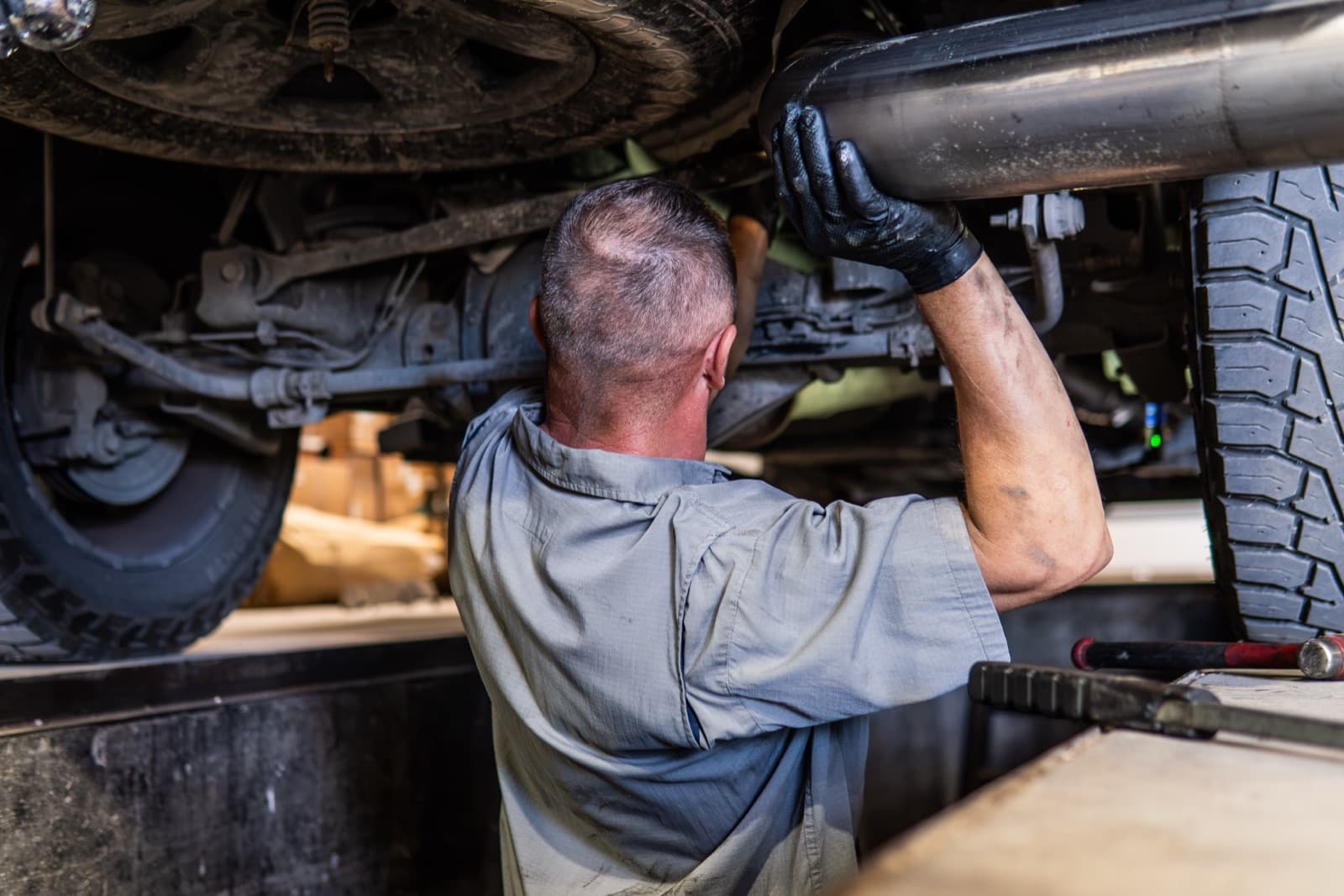 Technician inspecting a truck in a service bay